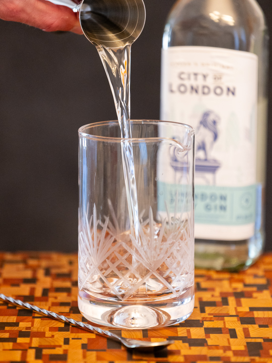 Pouring gin into a stirring glass