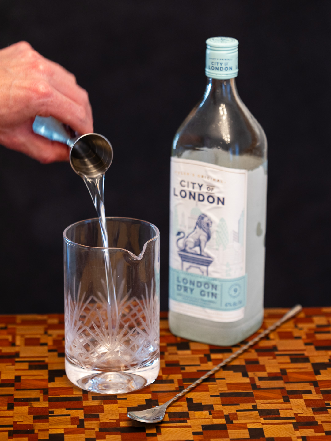 Pouring gin into a mixing glass