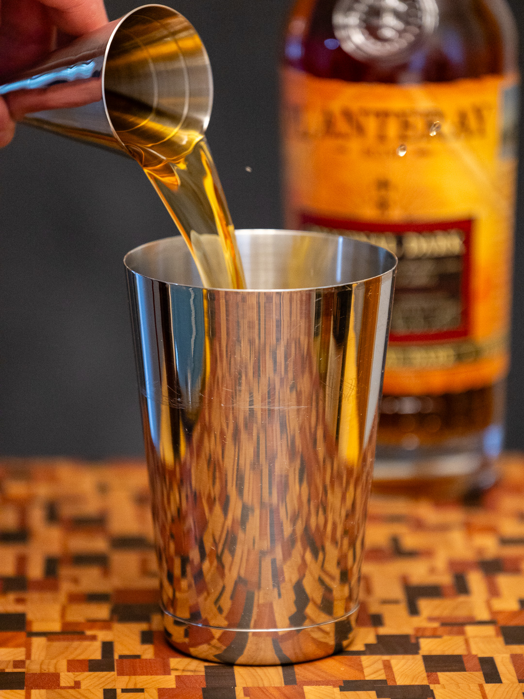 Pouring dark rum into a cocktail shaker