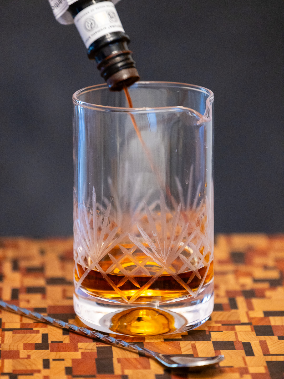 Dashing Angostura bitters into a mixing glass