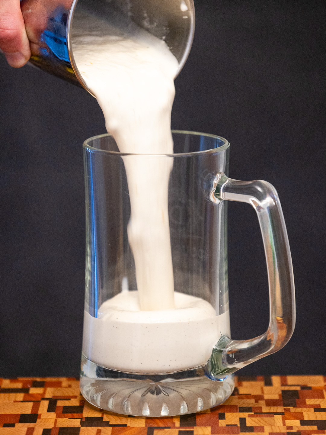 Pouring the milkshake into a glass mug