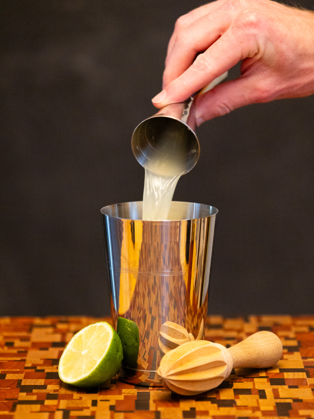 Pouring lime juice into a cocktail shaker