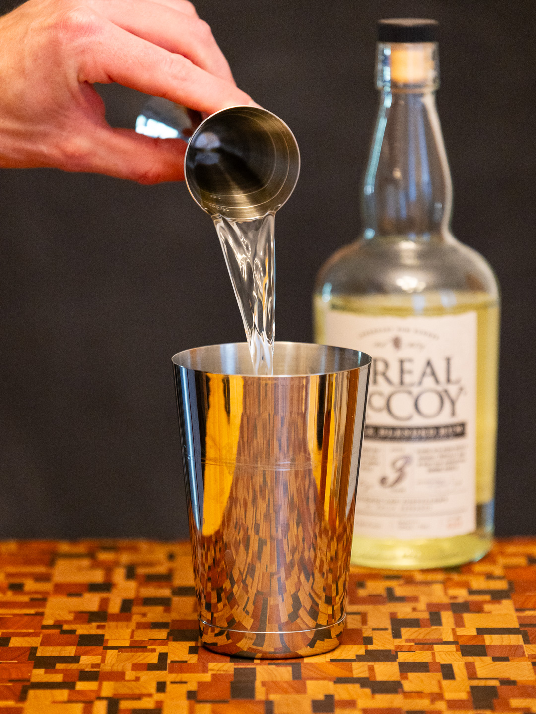 Pouring white rum into a cocktail shaker