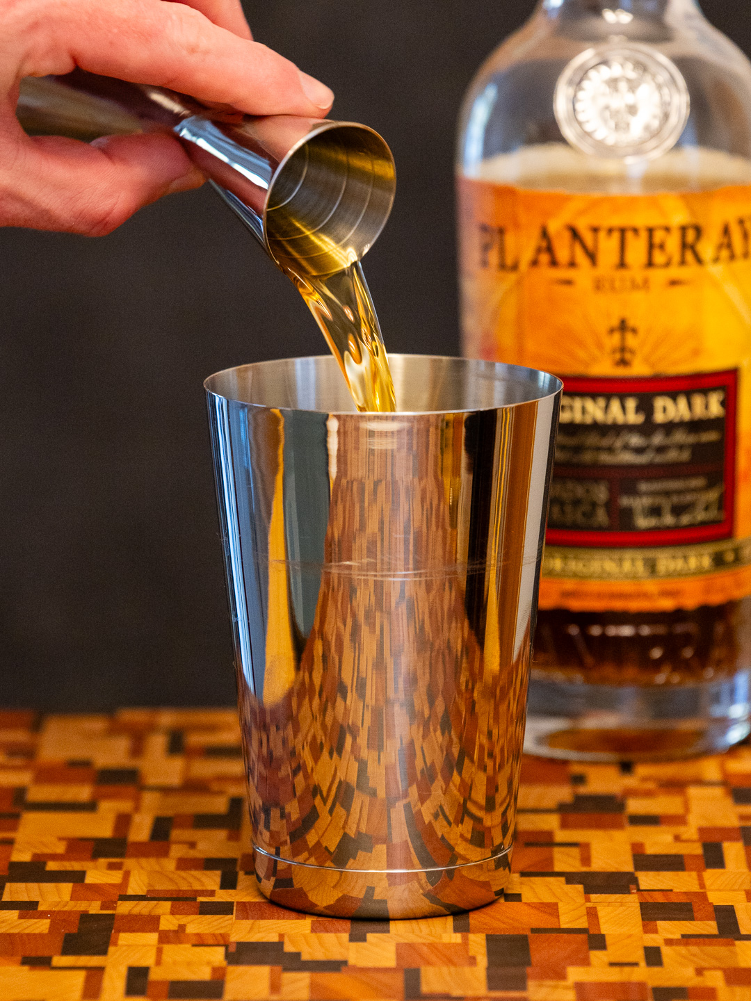 Pouring dark rum into a cocktail shaker