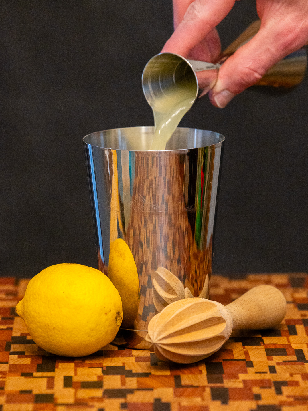 Pouring lemon juice into a cocktail shaker