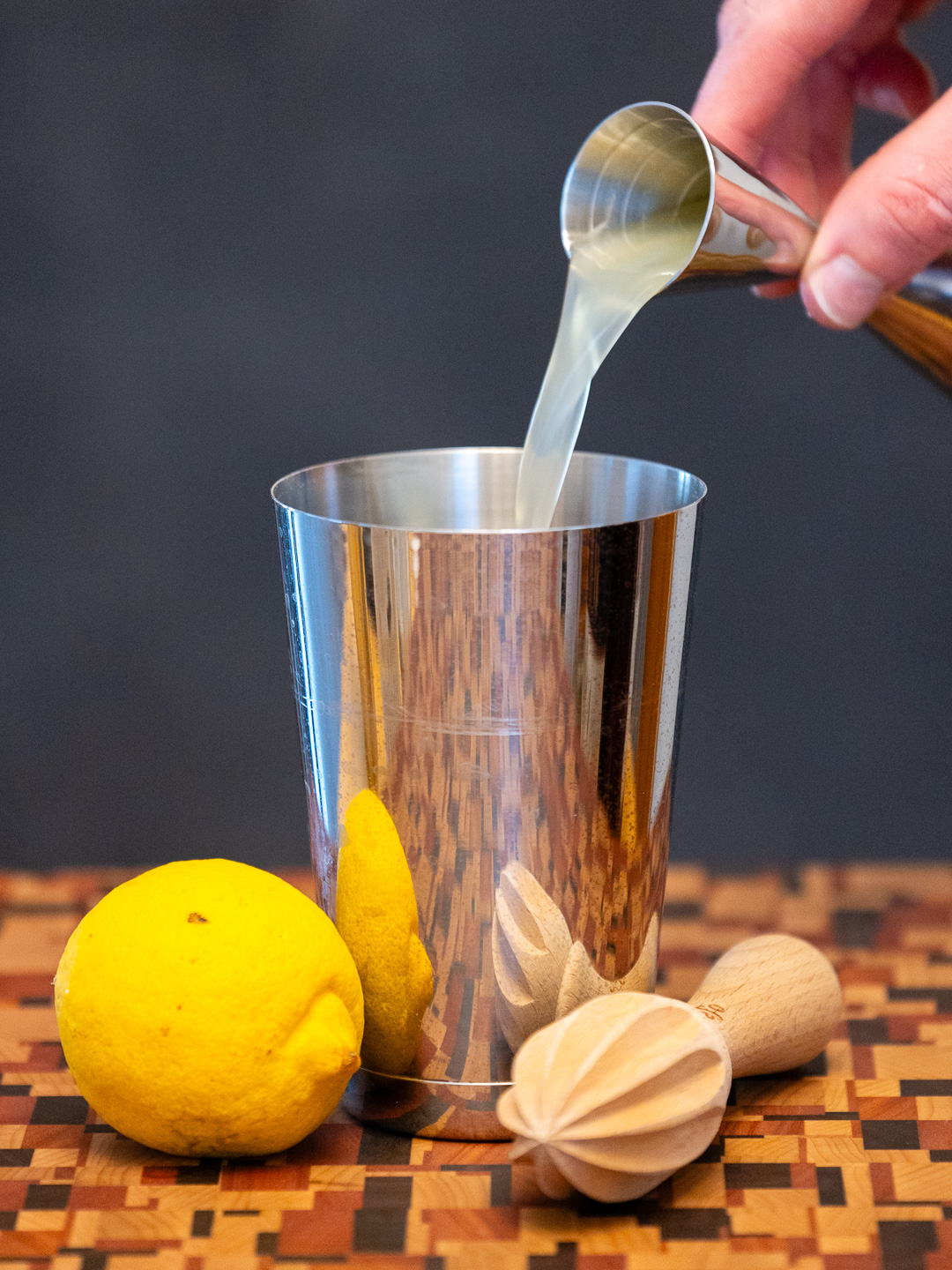 Pouring lemon juice into a cocktail shaker