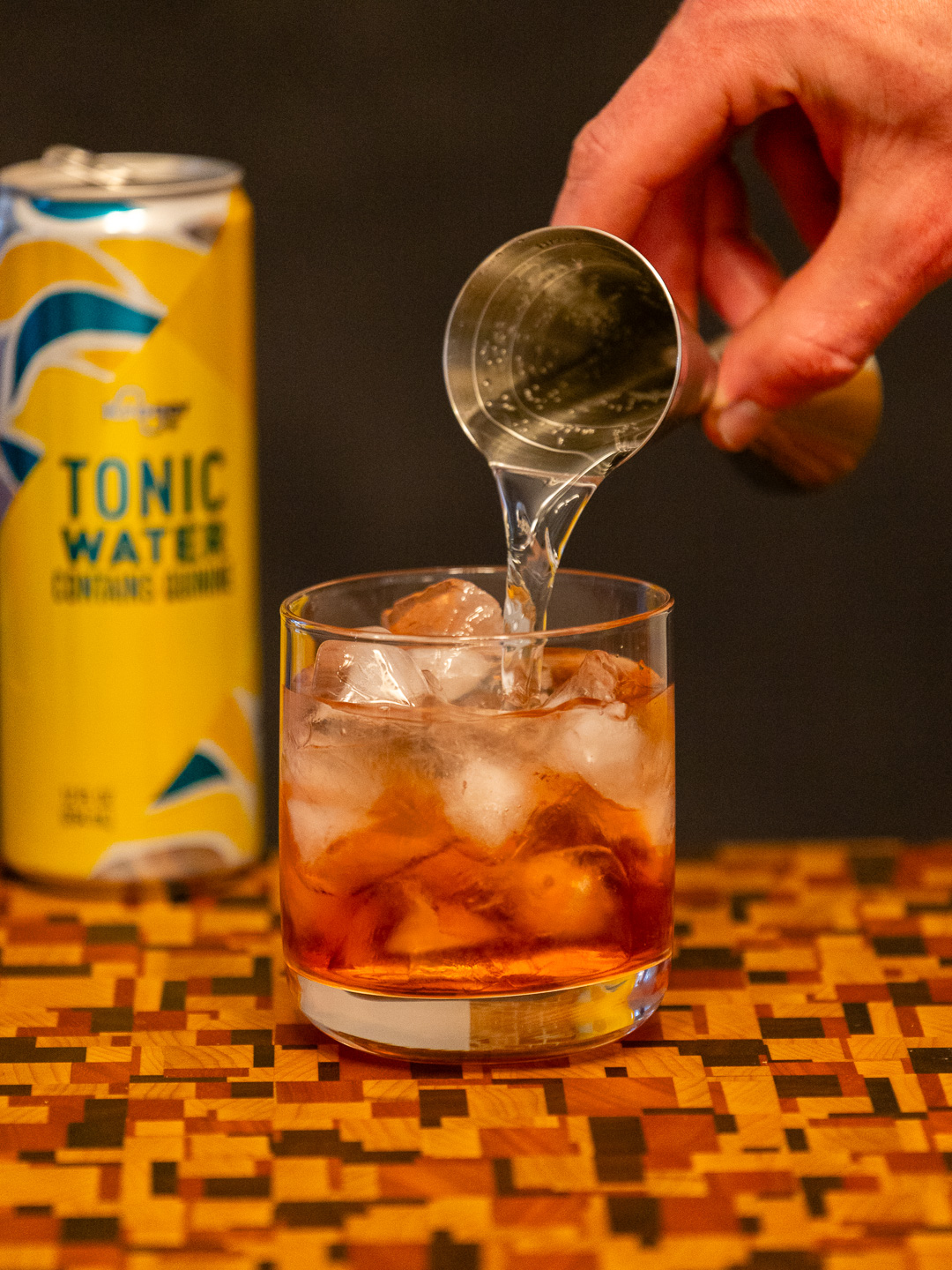 Pouring tonic water into a rocks glass