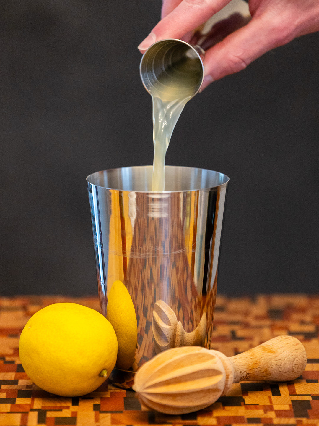 Pouring Lemon juice into a cocktail shaker