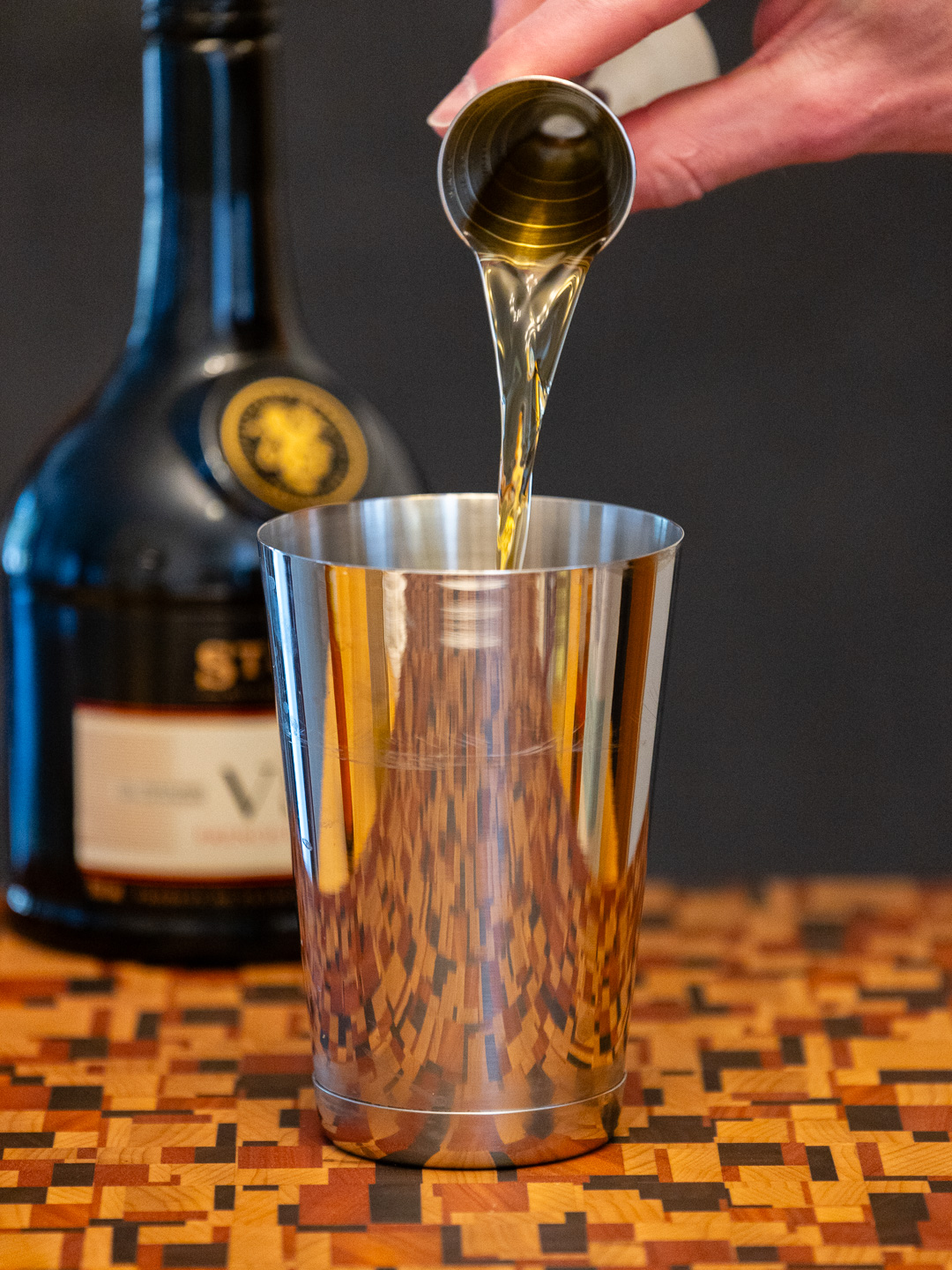 Pouring brandy into a cocktail shaker