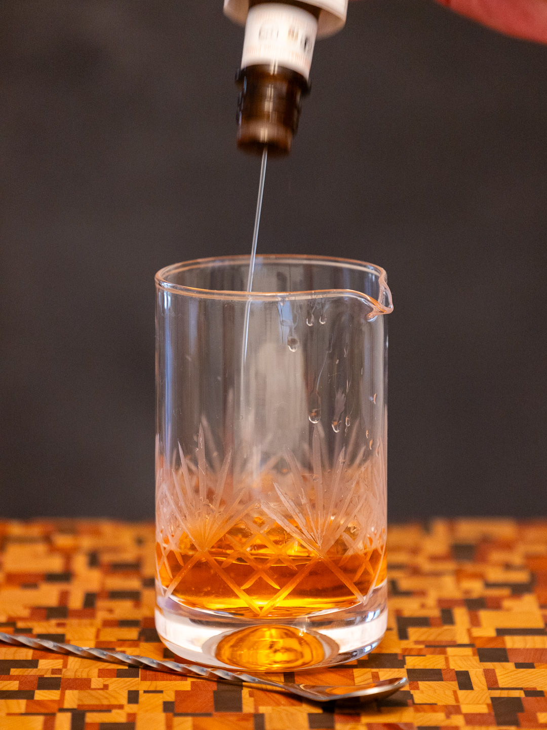 Dashing orange bitters into a mixing glass