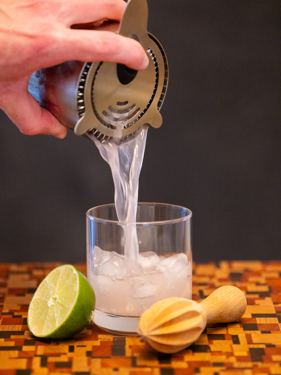 Straining the cocktail into a coupe glass