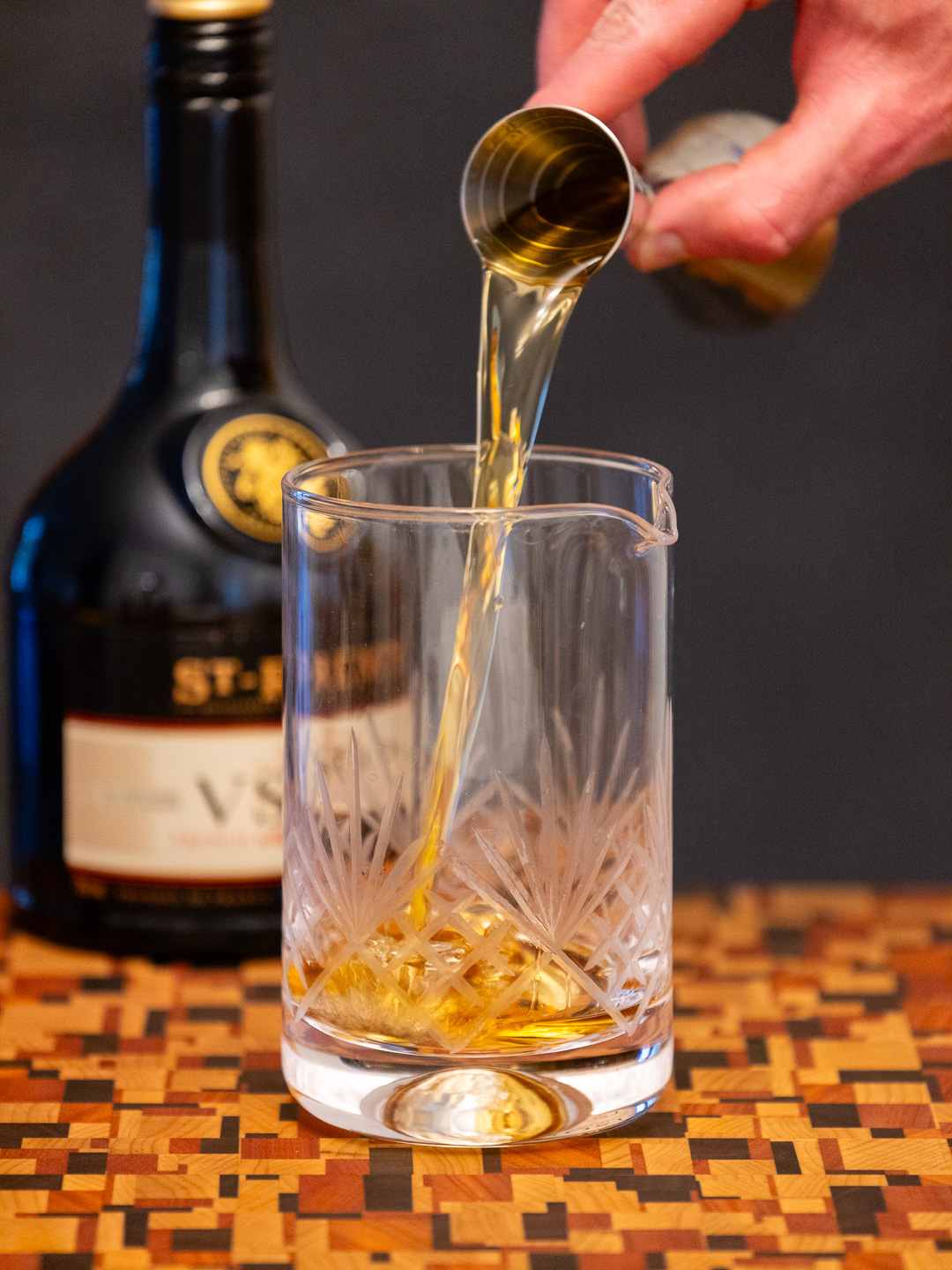 Pouring brandy into a mixing glass